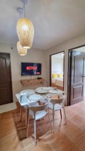 comedor con mesa, sillas y lámpara de araña en 2 Br Condo Unit Cagayan de Oro City en Cagayán de Oro