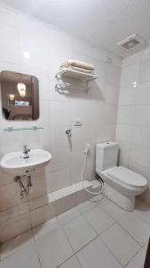 a white bathroom with a toilet and a sink at 2 Br Condo Unit Cagayan de Oro City in Cagayan de Oro