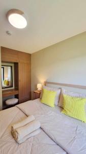 a bedroom with a large white bed with yellow pillows at 2 Br Condo Unit Cagayan de Oro City in Cagayan de Oro