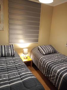 two beds sitting next to each other in a bedroom at San Pedro de la Paz by Luxury Apartment Chile in San Pedro de la Paz