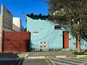 un edificio blu con una porta rossa su una strada di Quarto Central a Guararema