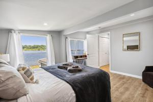 a bedroom with a large bed with a view of the water at Landmark Lakehouse - luxury living in PLX in Akron