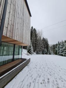 a snow covered road next to a building at ALPINA NEW apartment in the mountains in Špindlerův Mlýn