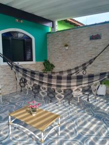a patio with a table and chairs and a wall at Itanhaem - Casa com Piscina in Itanhaém