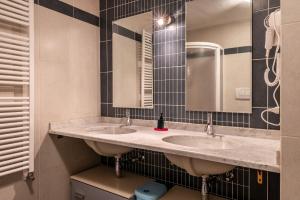 a bathroom with two sinks and a mirror at Apartment Pordoi in Campitello di Fassa