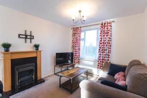 a living room with a couch and a fireplace at April Disc - Long Stay - Contractors in Swindon