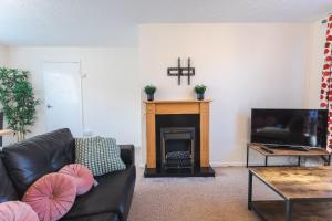 a living room with a couch and a fireplace at April Disc - Long Stay - Contractors in Swindon