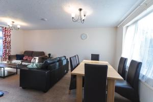 a living room with a table and a couch at April Disc - Long Stay - Contractors in Swindon