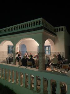 伊里德的住宿－Wostel Djerba，一群人坐在庭院的椅子上