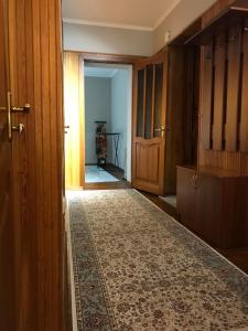 a hallway with wooden doors and a rug at Уютный уголок рядом с ЦУМом и ГУМом in Bishkek