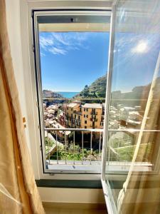 a window with a view of a city at The Manarola Main Plaza in Manarola