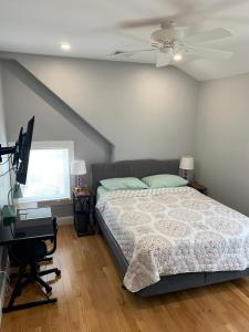 a bedroom with a bed and a television and a desk at RobbinsStreetWaltham in Waltham
