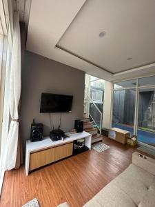 ein Wohnzimmer mit Flachbildfernseher und Couch in der Unterkunft Villa Jasmine Batu in Batu