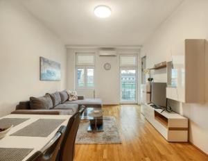 - un salon avec un canapé et une télévision dans l'établissement Flarent Vienna Apartments-HG, à Vienne