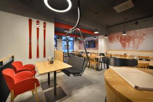 a restaurant with wooden tables and red chairs at Hotel Element in Lipno nad Vltavou +149 photos