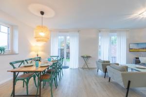 a dining room and living room with a table and chairs at Kleine Flucht in Tating +20 photos
