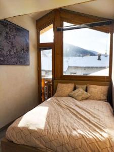 a bedroom with a large bed with a window at Chalet spacieux & spa in Landry