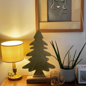 Un arbre de Noël assis sur une table à côté d'une lampe dans l'établissement Les Suites de Catherine, la 35, à Nancy