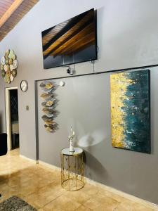 a room with a table and a painting on the wall at Blissett Apt, Your Jamaican Home in Kingston