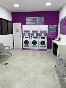 a laundry room with washing machines and a purple wall at Loft com vista da praia da Costa 612 in Vila Velha