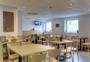 un restaurant avec des tables, des chaises et un tableau noir sur le mur dans l'établissement B&B HOTEL Reims Centre Gare, à Reims