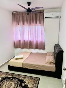 a bedroom with a bed with a ceiling fan and a window at Omak Kito Homestay Melaka in Kampong Alor Gajah