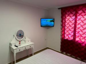 a room with a vanity and a mirror and a red curtain at Piso cerca de la playa. in Melilla