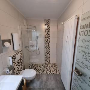 a bathroom with a shower with a toilet and a sink at Maberg Ferienwohnung auf Scheid in Waldeck