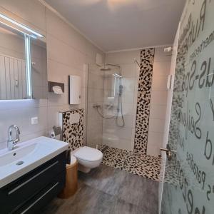 a bathroom with a sink and a toilet and a shower at Maberg Ferienwohnung auf Scheid in Waldeck