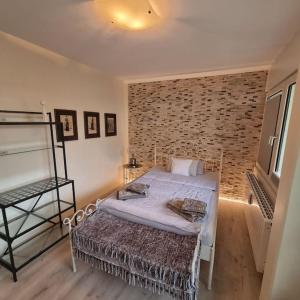 a bedroom with a bed and a brick wall at Maberg Ferienwohnung auf Scheid in Waldeck