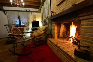 a living room with a fireplace and a couch at Γήλοφος in Ano Trikala +17 photos
