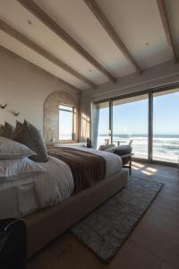 a bedroom with a large bed with a view of the ocean at Escape to the Beach in Wilderness