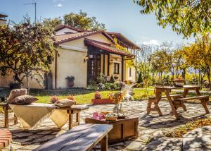 un patio con bancos y mesas frente a una casa en Villa Anthemia, en Nausa