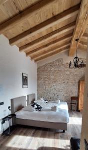 een slaapkamer met een bed en een bakstenen muur bij Agriturismo La Pina in Tarzo