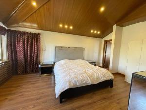 sypialnia z łóżkiem i dwoma stołami w obiekcie Horizon Villa w mieście Amman