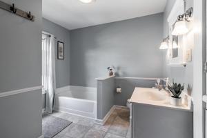 een badkamer met een bad, een wastafel en een toilet bij Walk to Downtown Kent - 3 BR House w Patio & Yard in Kent