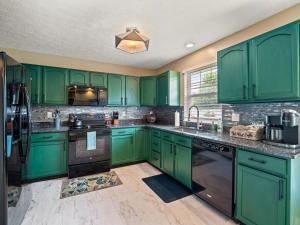 a green kitchen with black appliances and green cabinets at Steps to CLE Clinic - Great for Families - ADA in Cleveland