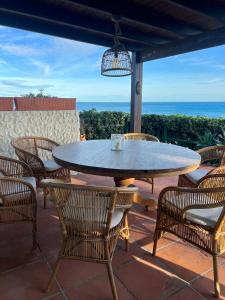 einen Tisch und Stühle auf einer Terrasse mit Meerblick in der Unterkunft Beach Villa Dorada in Estepona