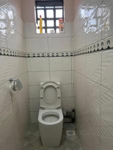 uma pequena casa de banho com um WC e uma janela em C & T luxury apartments em Nakuru