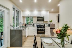 a kitchen with white cabinets and a table with a vase of flowers at Beautiful place with a great location, free parking, WiFi & large TV. in Federal Way