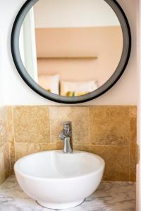 a bathroom with a white sink and a round mirror at Cocon à Toulon proche de l'Arsenal. 10mn à pied du centre in Toulon