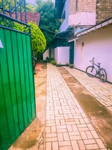 a bike parked next to a building with a green door at Bloom Guest House in Mirissa