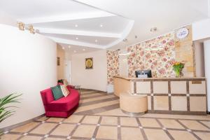 a living room with a red chair and a counter at Hotel Victory Home - 10min Lotnisko Chopina, 15min to Zachodni, 5min to Progresja in Warsaw