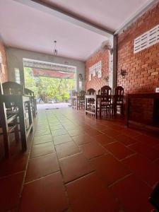 una habitación vacía con mesas, sillas y una pared de ladrillo en ING ING GUESTHOUSE en Koh Rong Sanloem
