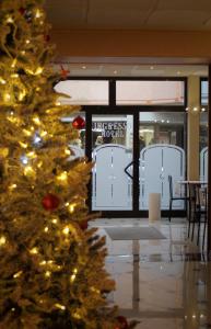 uma árvore de Natal em frente a uma loja em Hotel Avogadro em San Pellegrino Terme