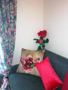 un sofá con una almohada y un jarrón con flores en Chez Frida en Le Puy-en-Velay