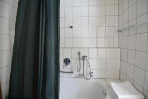 uma casa de banho com uma cortina de chuveiro e uma banheira em Calm GaP em Garmisch-Partenkirchen