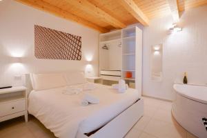 a white bedroom with a bed and a sink at TS ROOMS - Guest House Sciola in San Sperate