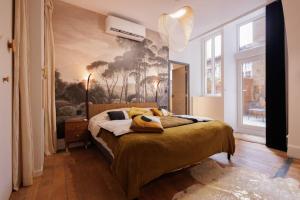 a bedroom with a bed with a painting on the wall at La suite du 21 - jacuzzi - sauna - centre ville in Bourg-en-Bresse