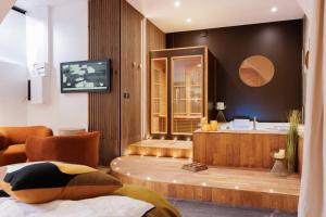 Cette chambre d'hôtel dispose d'une baignoire et d'une télévision. dans l'établissement La suite du 21 - jacuzzi - sauna - centre ville, à Bourg-en-Bresse
